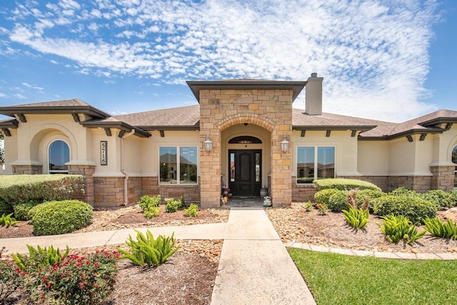 5716 S Oso Pkwy, Corpus Christi, TX 78414 - view of front facade with stone siding, stucco siding, a chimney, and a shingled roof