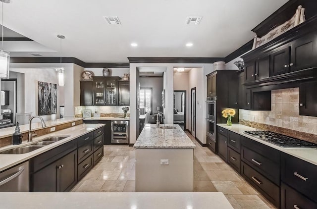 5716 S Oso Pkwy, Corpus Christi, TX 78414 - kitchen with a sink, appliances with stainless steel finishes, backsplash, an island with sink, and recessed lighting