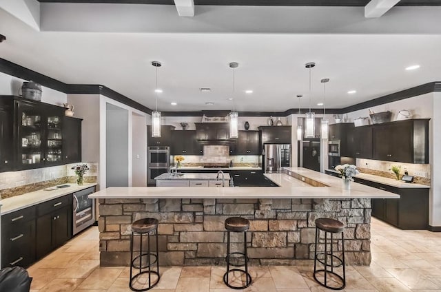 5716 S Oso Pkwy, Corpus Christi, TX 78414 - kitchen with stainless steel appliances, a spacious island, tasteful backsplash, a breakfast bar, and recessed lighting