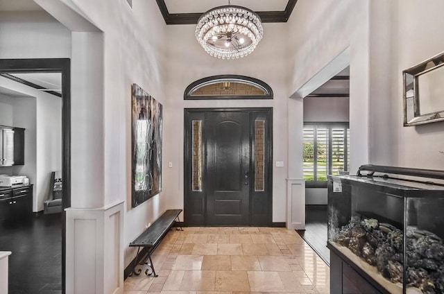 5716 S Oso Pkwy, Corpus Christi, TX 78414 - entryway with crown molding, a towering ceiling, baseboards, and a chandelier