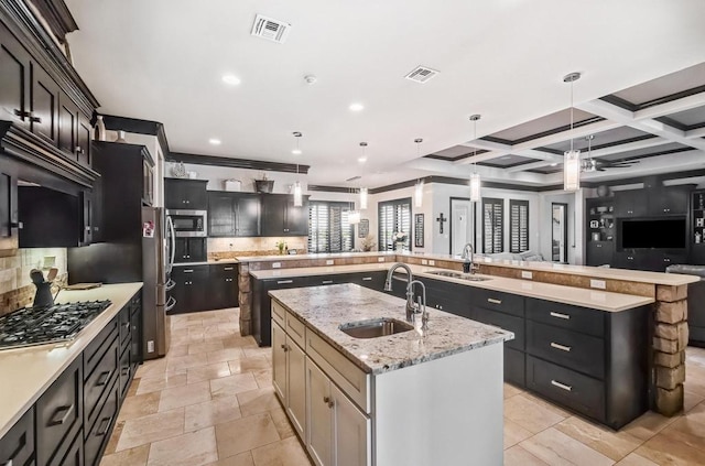 5716 S Oso Pkwy, Corpus Christi, TX 78414 - kitchen with a spacious island, a sink, stainless steel appliances, decorative backsplash, and beamed ceiling