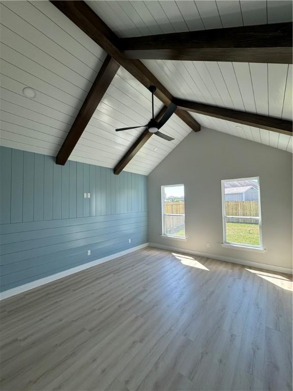 bonus room with wood walls, vaulted ceiling with beams, ceiling fan, light wood-type flooring, and wood ceiling