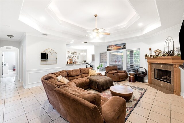 living room with ceiling fan, ornamental molding, and a tray ceiling