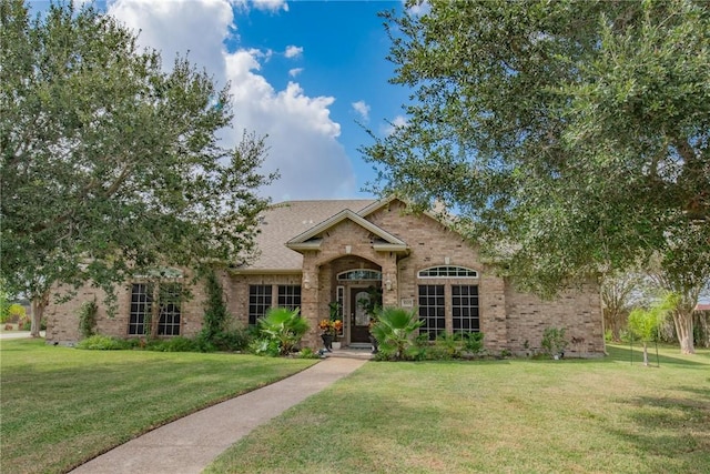 5309 Fox Glove, Corpus Christi, TX 78413 - traditional-style house featuring brick siding, a front lawn, and roof with shingles
