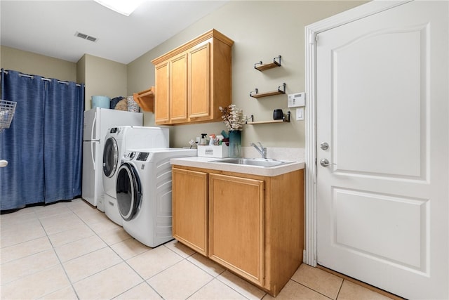 washroom featuring washing machine and clothes dryer, sink, and light tile patterned floors