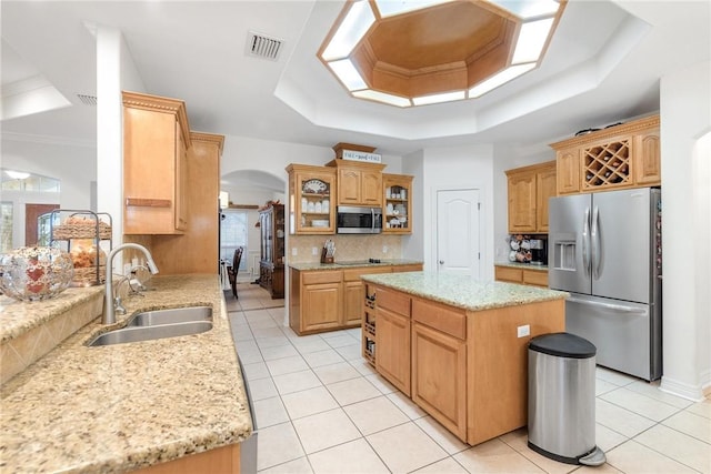 5309 Fox Glove, Corpus Christi, TX 78413 - kitchen featuring stainless steel appliances, a tray ceiling, a sink, arched walkways, and light tile patterned floors