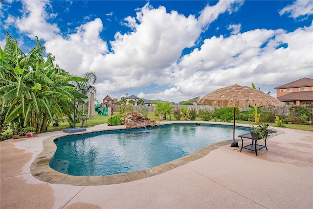 view of pool featuring a playground and a patio area