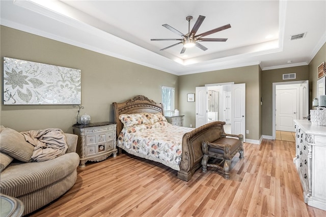 bedroom featuring ceiling fan, light hardwood / wood-style flooring, crown molding, and a tray ceiling