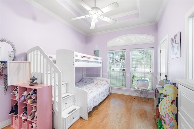 bedroom featuring light wood-type flooring, ceiling fan, and crown molding