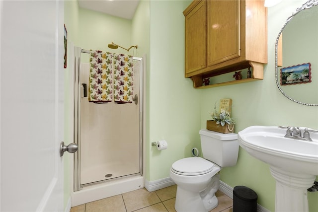 bathroom with walk in shower, toilet, sink, and tile patterned flooring