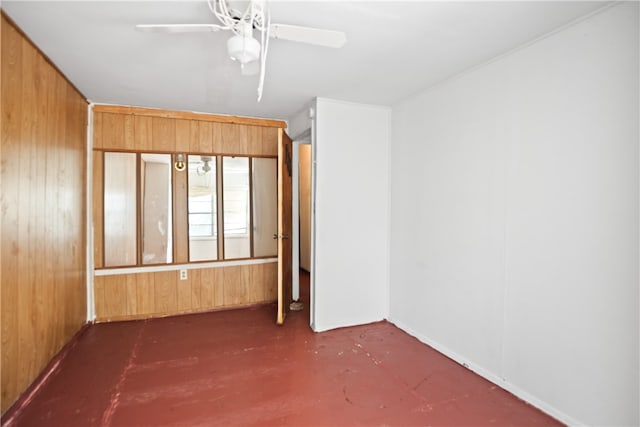 spare room featuring wooden walls and ceiling fan