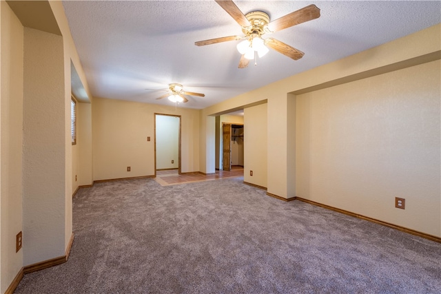 carpeted spare room featuring a textured ceiling and ceiling fan