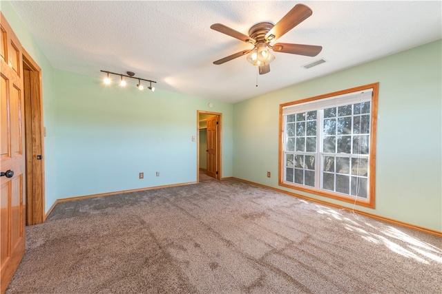 empty room featuring ceiling fan, a textured ceiling, and carpet flooring