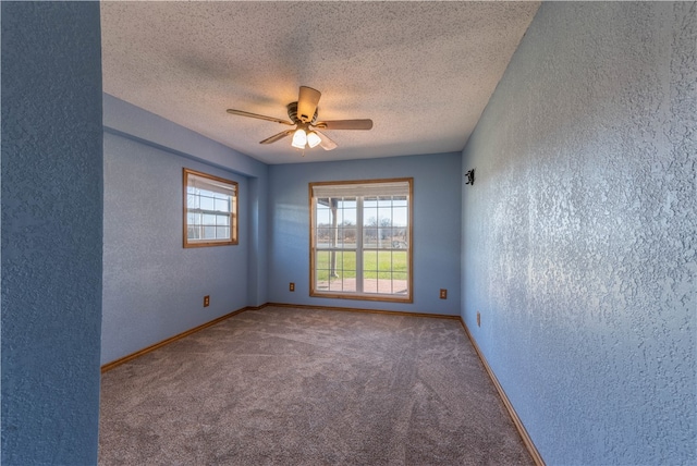 carpeted spare room with ceiling fan and a textured ceiling