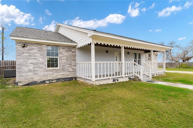 ranch-style house featuring a porch, central air condition unit, and a front lawn