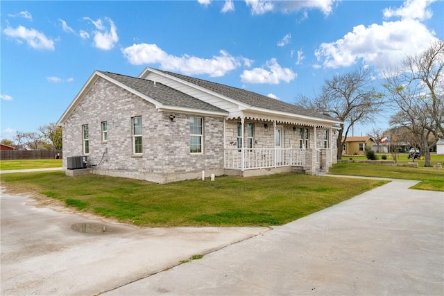 view of side of home with a lawn and central AC