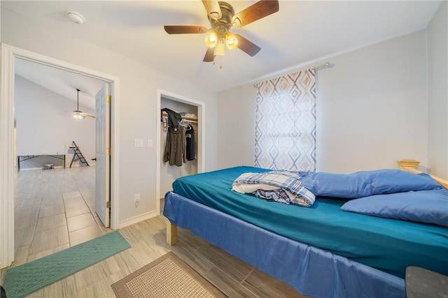 bedroom featuring ceiling fan, vaulted ceiling, wood-type flooring, and a closet