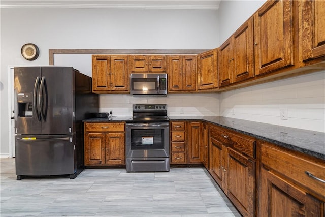 kitchen with backsplash, dark stone countertops, and stainless steel appliances