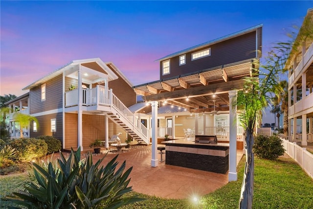 back house at dusk featuring a pergola, a yard, and a patio