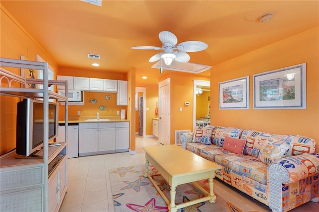 tiled living room with ceiling fan and sink