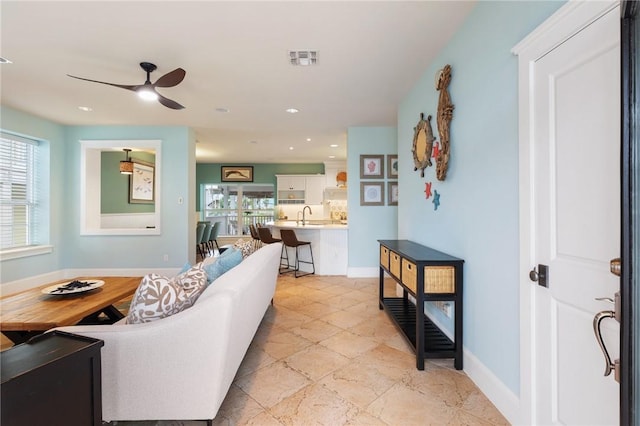 living room featuring ceiling fan and sink