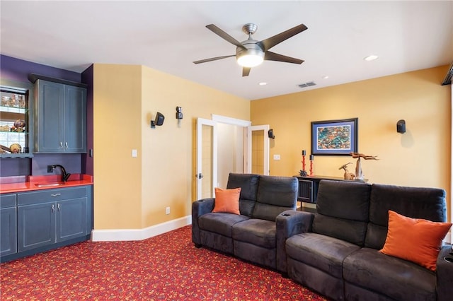 carpeted living room with ceiling fan and sink