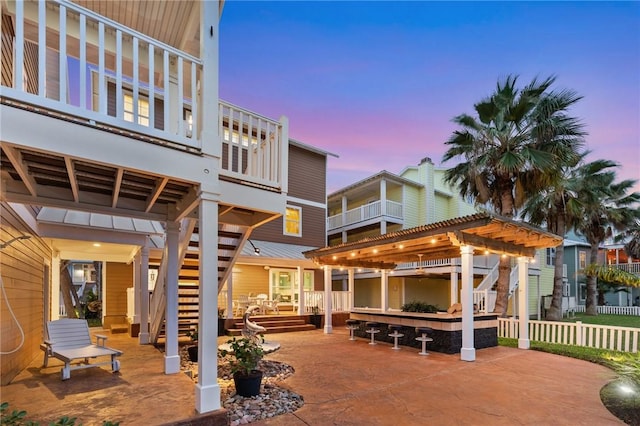 patio terrace at dusk with an outdoor bar and a pergola