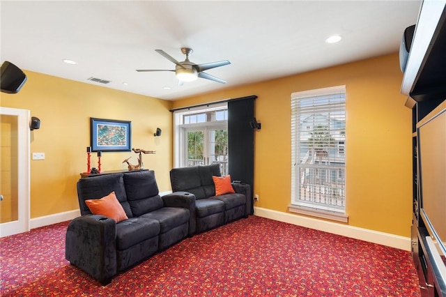 living room with ceiling fan, a wealth of natural light, and carpet