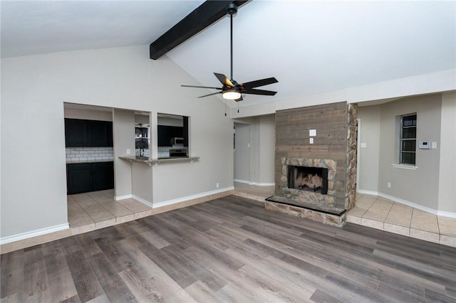 unfurnished living room featuring vaulted ceiling with beams, ceiling fan, a fireplace, and hardwood / wood-style flooring