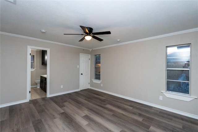 unfurnished bedroom with crown molding, ceiling fan, dark wood-type flooring, and ensuite bathroom