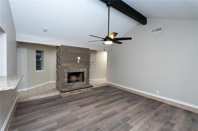 unfurnished living room with hardwood / wood-style floors, lofted ceiling with beams, ceiling fan, and a fireplace