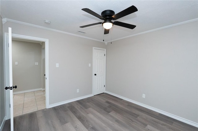 unfurnished bedroom with ceiling fan, a closet, hardwood / wood-style flooring, and ornamental molding