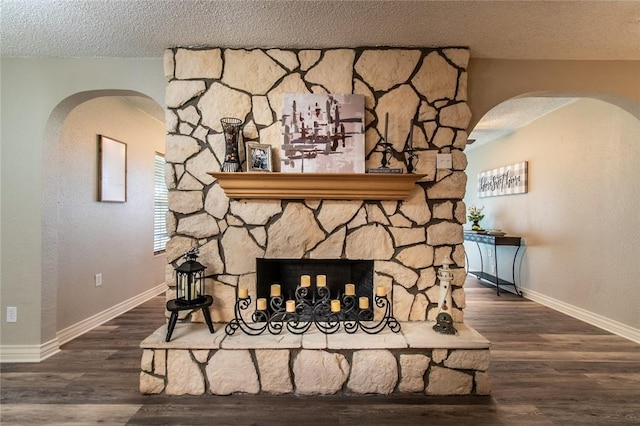 7322 Milky Way Dr, Corpus Christi, TX 78412 - detailed view of arched walkways, a stone fireplace, a textured ceiling, and wood finished floors