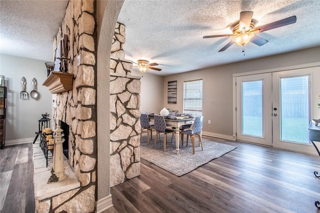 7322 Milky Way Dr, Corpus Christi, TX 78412 - dining space with a textured ceiling, a ceiling fan, wood finished floors, a stone fireplace, and french doors