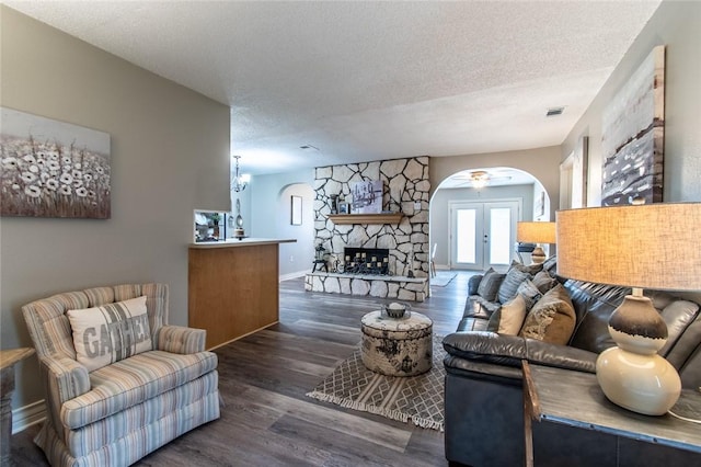 7322 Milky Way Dr, Corpus Christi, TX 78412 - living room with arched walkways, a textured ceiling, wood finished floors, and a stone fireplace