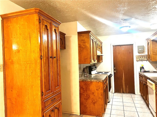 kitchen with sink, white appliances, a textured ceiling, and light tile patterned floors