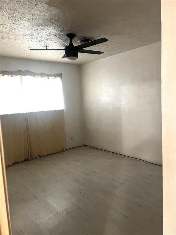 unfurnished room featuring a textured ceiling and ceiling fan