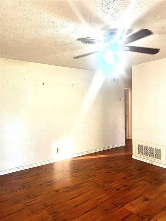 spare room featuring dark hardwood / wood-style flooring, a textured ceiling, and ceiling fan