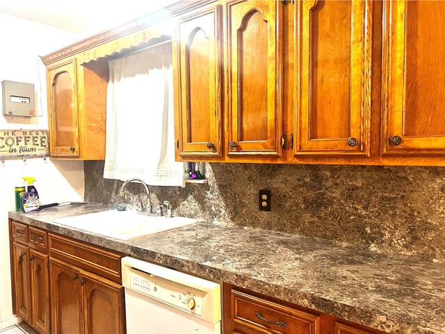 kitchen with dark stone counters, sink, dishwasher, and tasteful backsplash