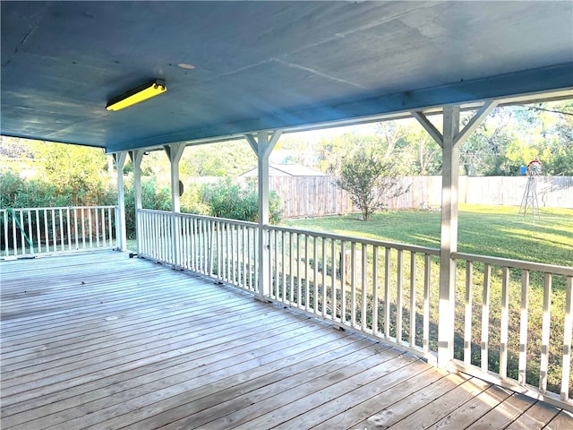 wooden terrace featuring a lawn