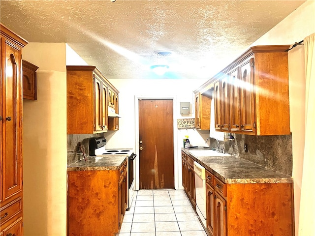 kitchen with sink, a textured ceiling, light tile patterned floors, backsplash, and white appliances