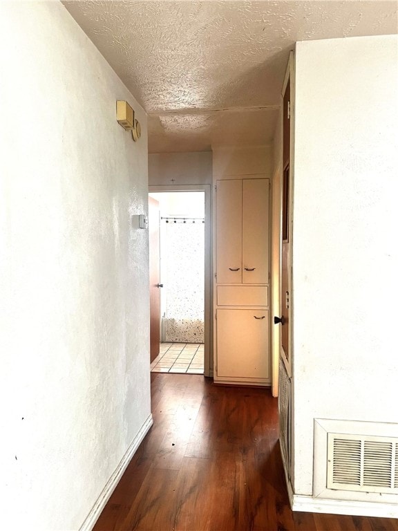 hallway featuring dark hardwood / wood-style flooring and a textured ceiling