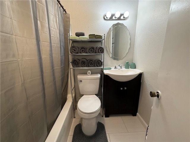 bathroom with toilet, vanity, and tile patterned floors