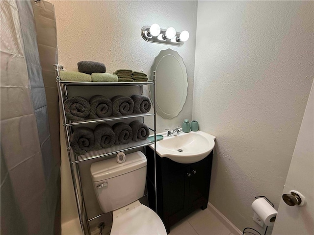 bathroom featuring tile patterned floors, vanity, and toilet