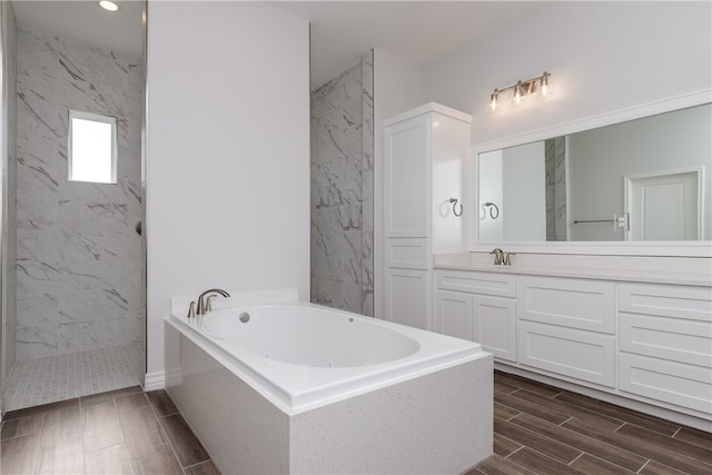 bathroom featuring shower with separate bathtub and vanity