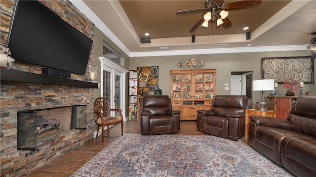 living room featuring dark hardwood / wood-style floors, a fireplace, ceiling fan, and a raised ceiling