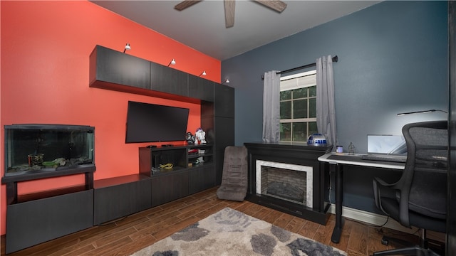 home office with ceiling fan, dark hardwood / wood-style floors, and a fireplace