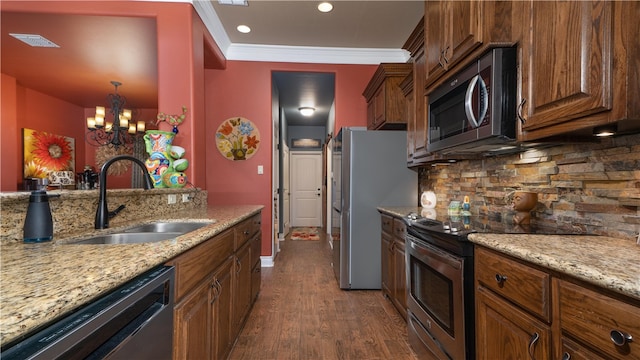 kitchen featuring sink, appliances with stainless steel finishes, a chandelier, crown molding, and dark wood-type flooring