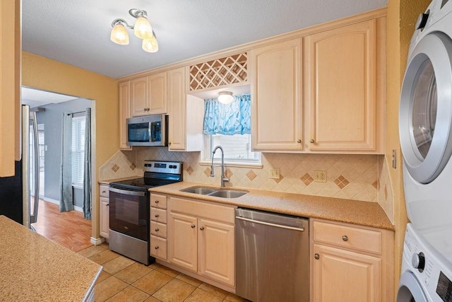 3605 Rushing Blvd, Corpus Christi, TX 78410 - kitchen featuring appliances with stainless steel finishes, estacked washer and dryer, a sink, and light brown cabinetry