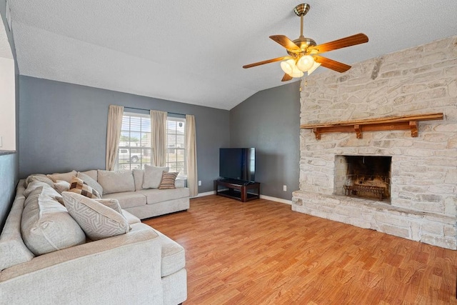 3605 Rushing Blvd, Corpus Christi, TX 78410 - living room featuring vaulted ceiling, ceiling fan, light wood-type flooring, a textured ceiling, and a fireplace